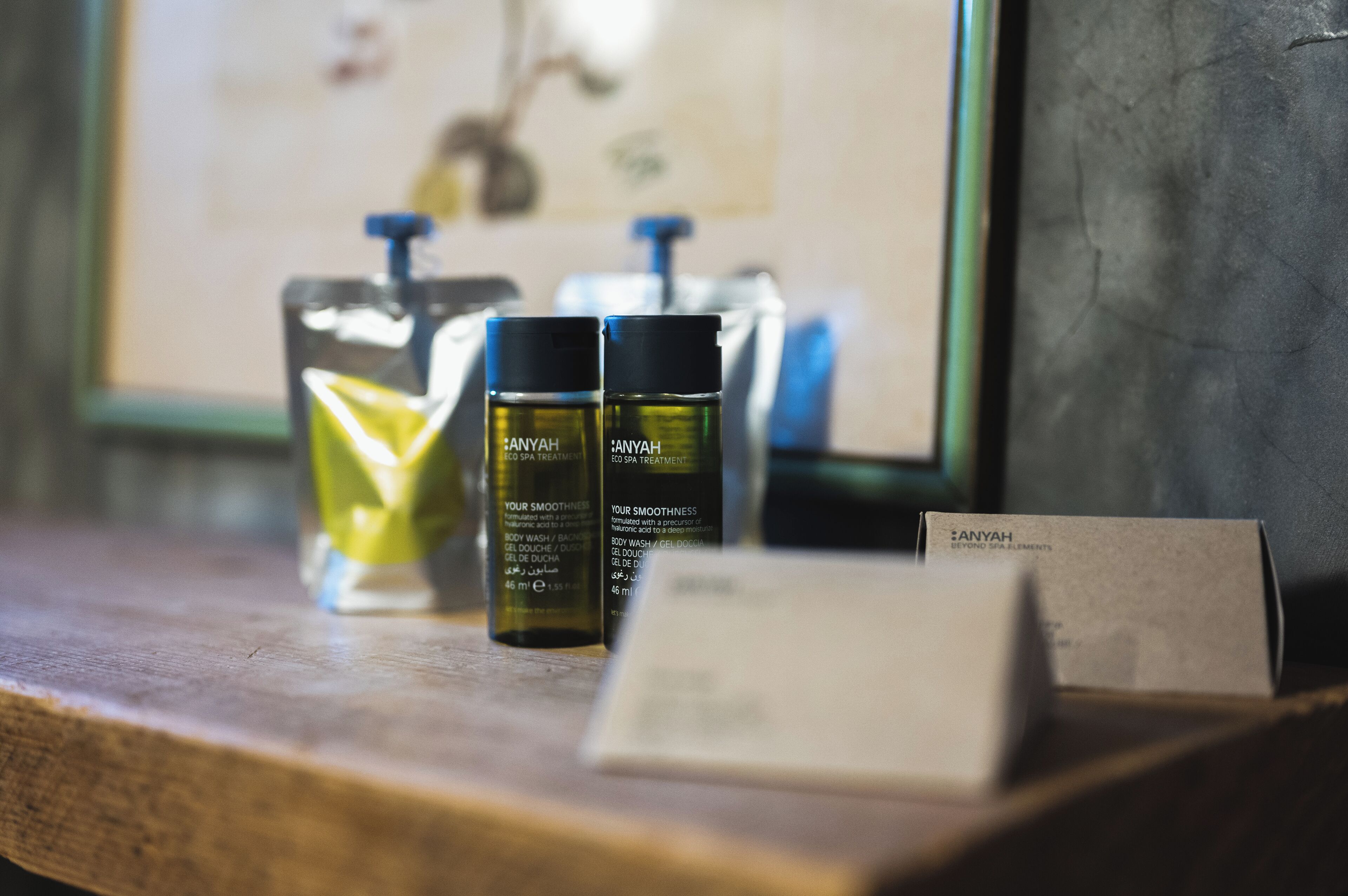 A wooden shelf with two bottles of body wash and a card.