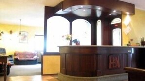 A reception desk with a wooden finish and a sign that reads "HEN". - Saint Nicolas (Saint-Nicolas)
