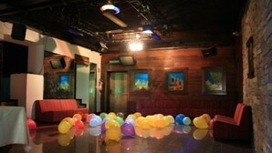 A room with a polished floor, red seating, and colorful balloons. - Saint Nicolas (Saint-Nicolas)