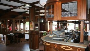 A restaurant with a wooden interior, a bar area, and a seating section. - Saint Nicolas (Saint-Nicolas)