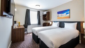 A hotel room with two beds, a desk with a flat-screen TV, a chair, and a painting on the wall. - Crown, Droitwich by Marston's Inns (Droitwich)