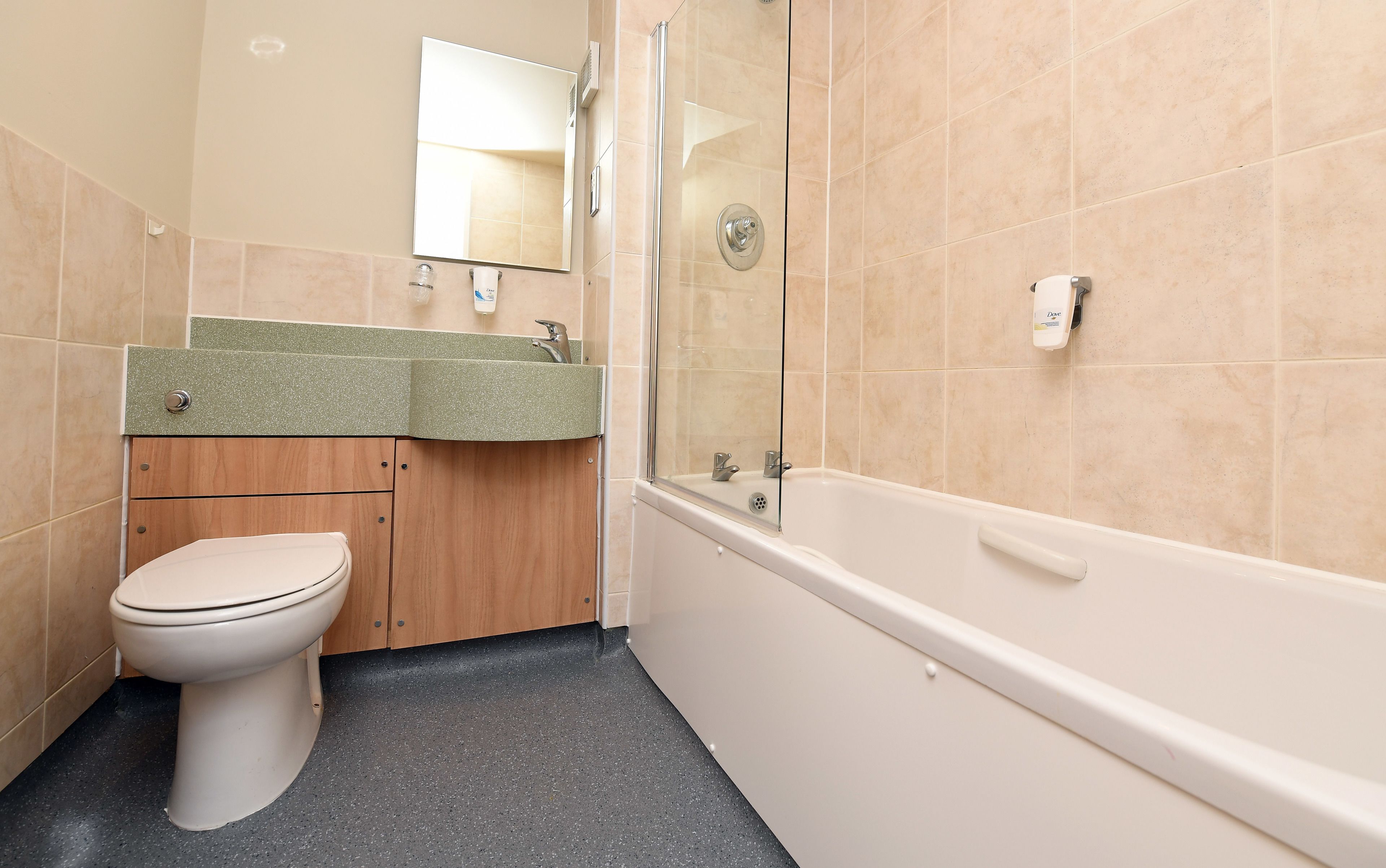 A bathroom with a toilet, sink, mirror, shower, and bathtub.