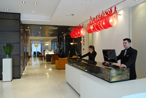 A modern reception desk with a receptionist and a guest.