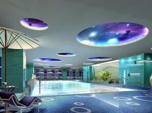 Un área de piscina interior moderna con diseños circulares en el techo y una piscina central.