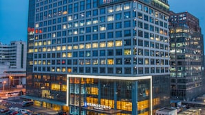 Un hotel a più piani con una moderna facciata in vetro e insegne illuminate.