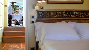 A hotel room with a bed, a nightstand, a lamp, and a framed picture on the wall. - Hotel Villa Duse (Rome)