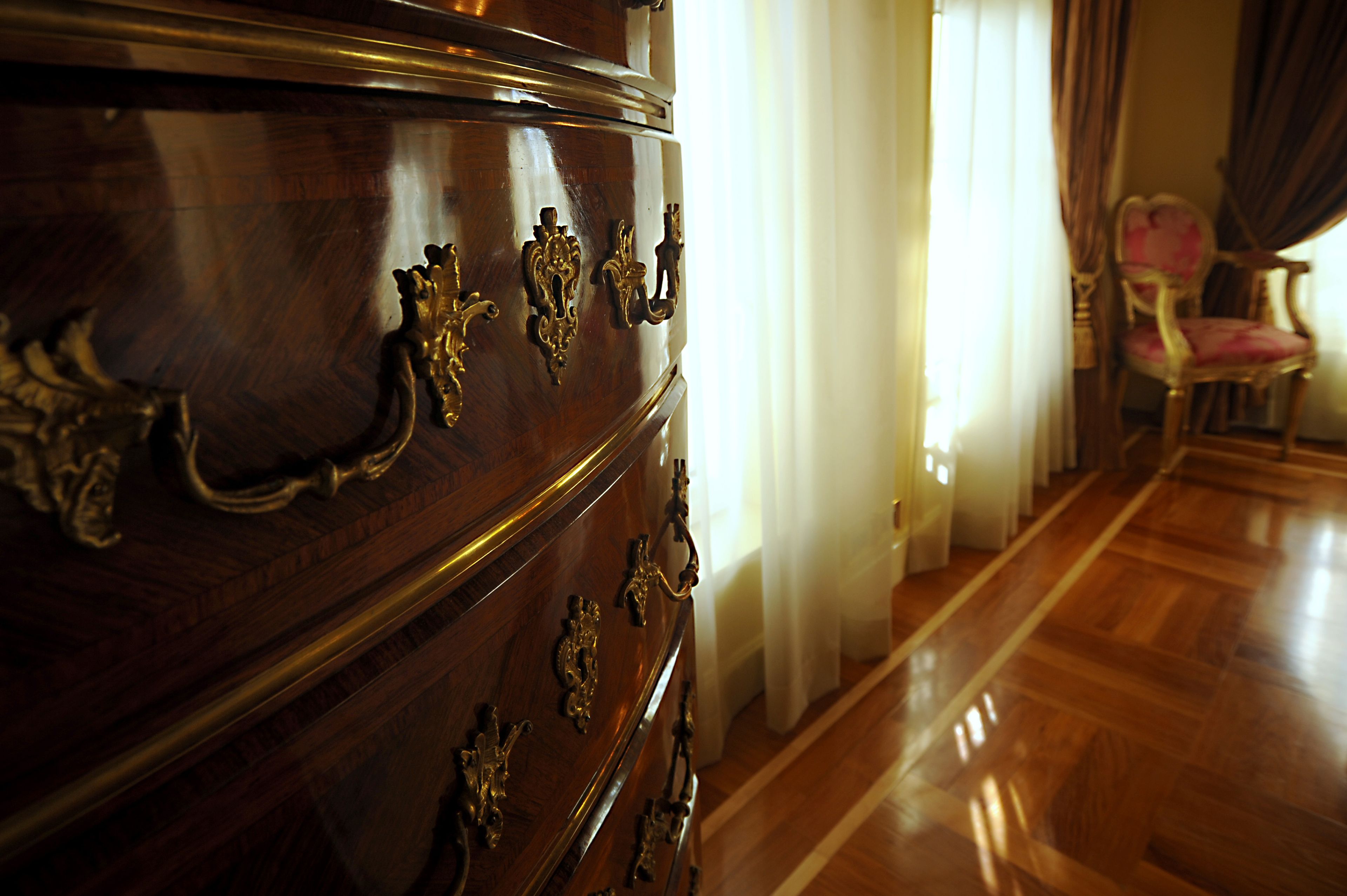 Un aparador de madera con elegantes pomos de latón y un piso de madera pulida.