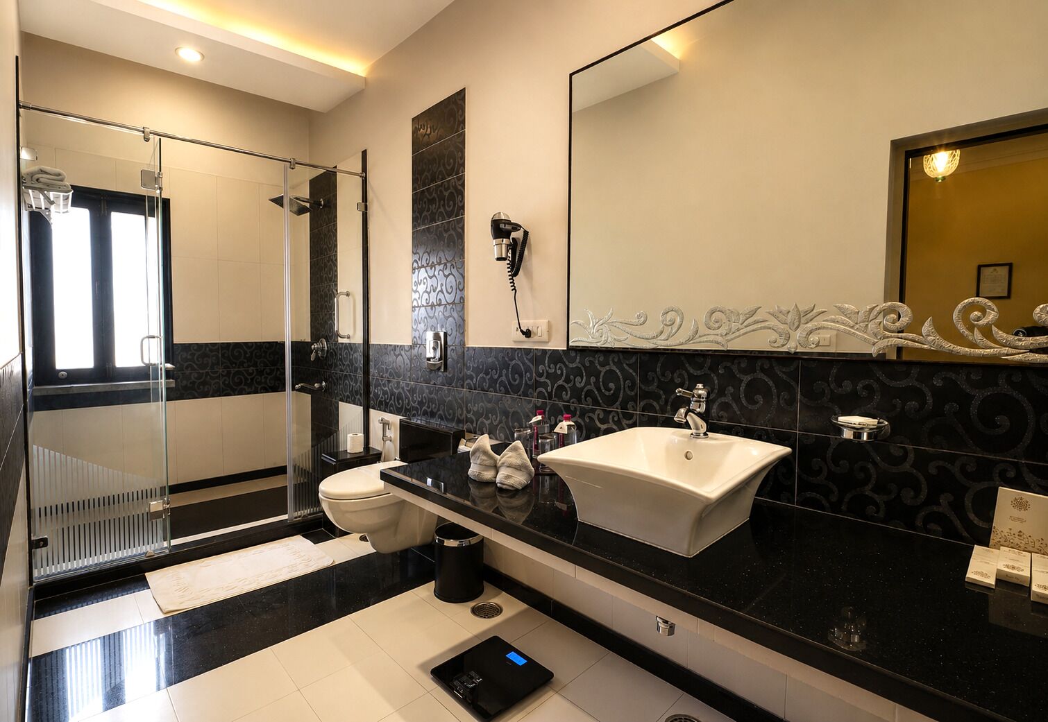 A modern bathroom with a glass shower enclosure, a white sink, and a large mirror.