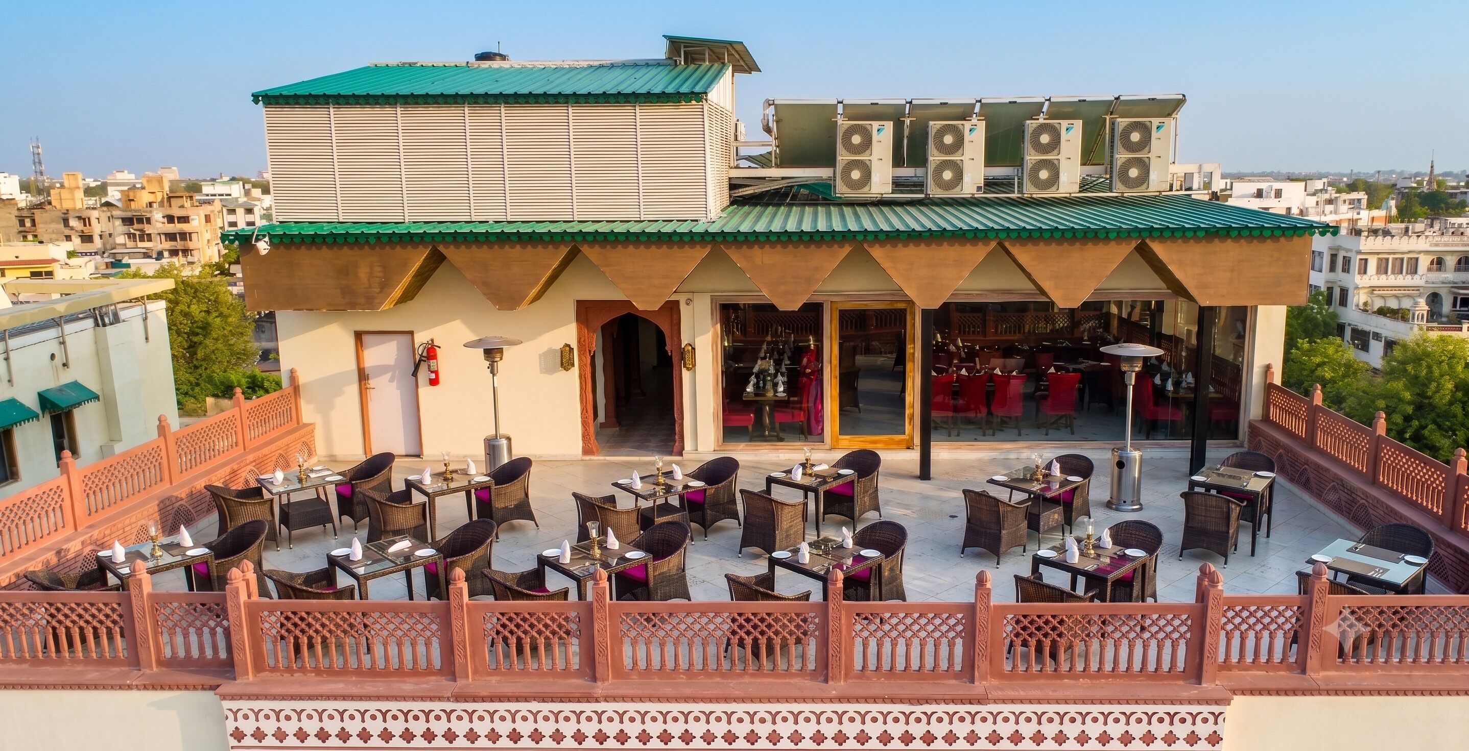 Un restaurante en la azotea con mesas al aire libre, vistas de la ciudad y elementos arquitectónicos tradicionales.
