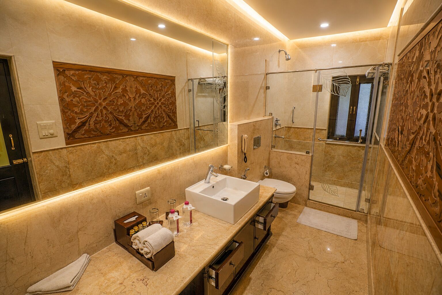 A modern bathroom with a large mirror, a sink, a toilet, and a shower area.