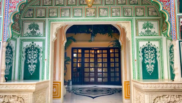 Una entrada ornamentada con detalles tallados y un gran portón.