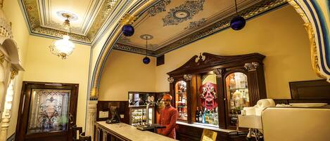 Un espace bar doté d’un comptoir en marbre, d’un plafond décoré et d’un barman.