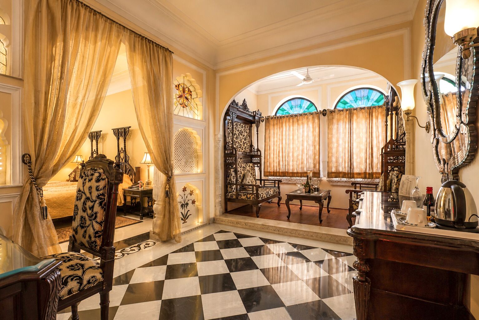 A luxurious room with a checkered floor, ornate furniture, and a large mirror.