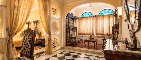 A luxurious room with a checkered floor, ornate furniture, and a large mirror.