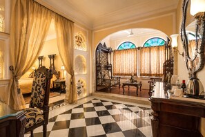Una habitación lujosa con suelo a cuadros, muebles ornamentales y un espejo grande.