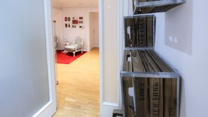 A room with a wooden floor, a red carpet, and a white chair. - Petit Hotel (Barcelona)
