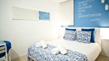 Une chambre d’hôtel avec un lit, une chaise et un mur orné d’une citation.