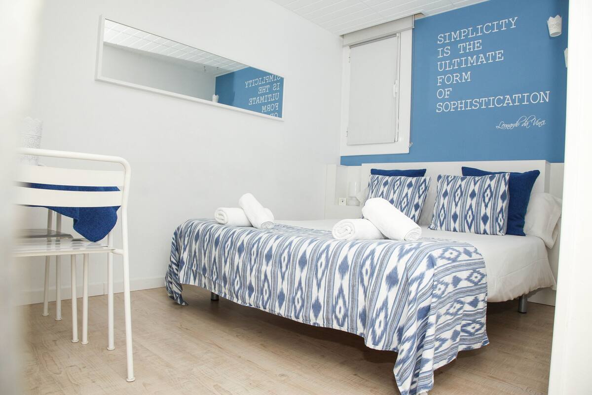 Un dormitorio con una cama, una silla y una pared con una cita.