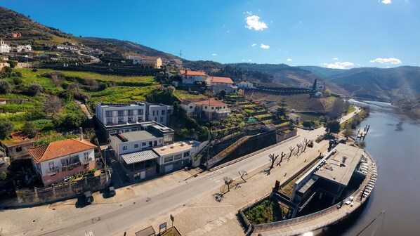 A hotel with a modern design, located near a river with a bridge. - Hotel Folgosa Douro (Armamar)
