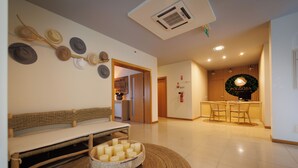 A modern living room with a bench, a round table with candles, and a kitchen area with a sign reading "FOLGOSA". - Hotel Folgosa Douro (Armamar)