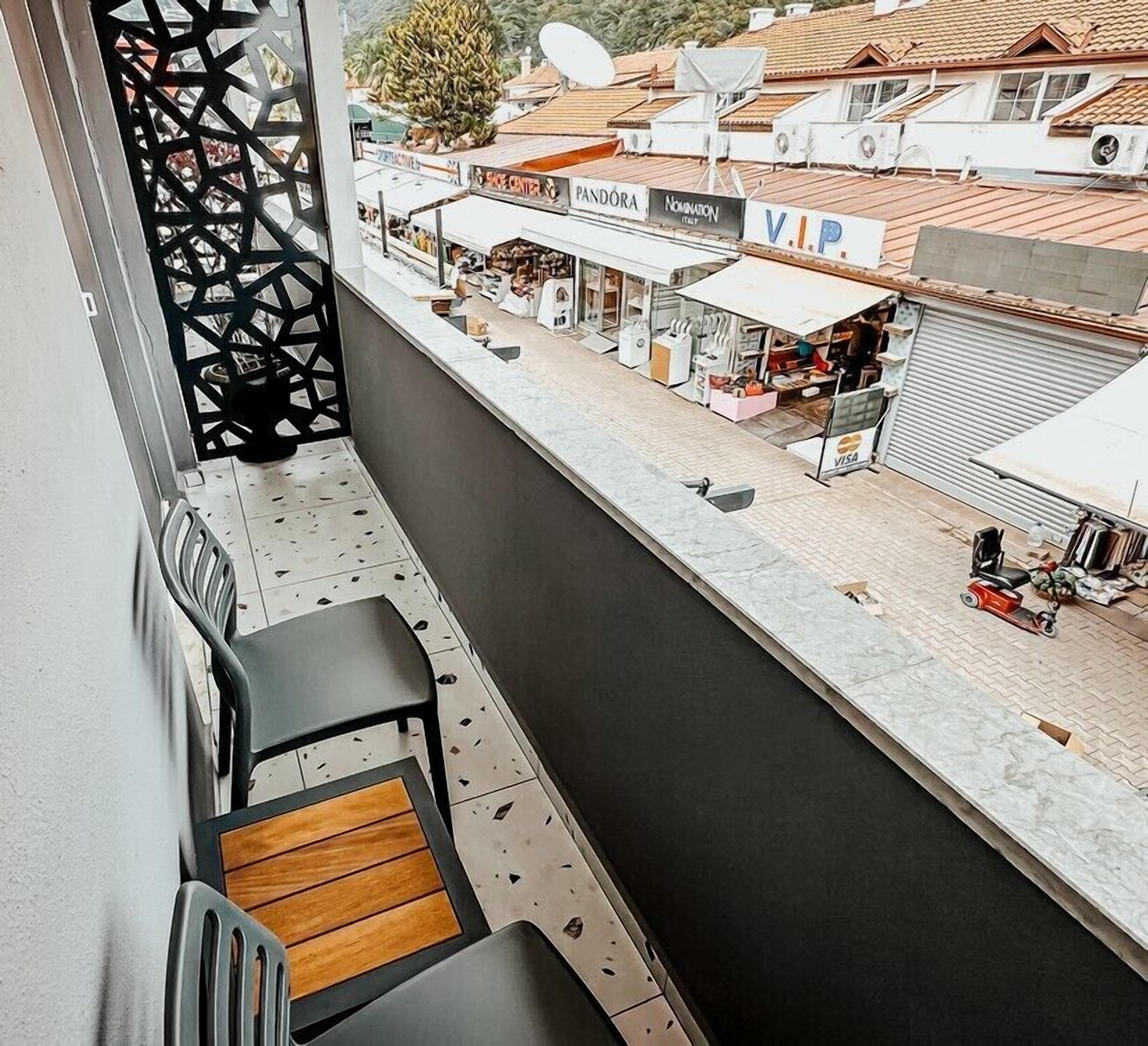 A balcony with a view of a street, including shops and a 'VIP' sign.