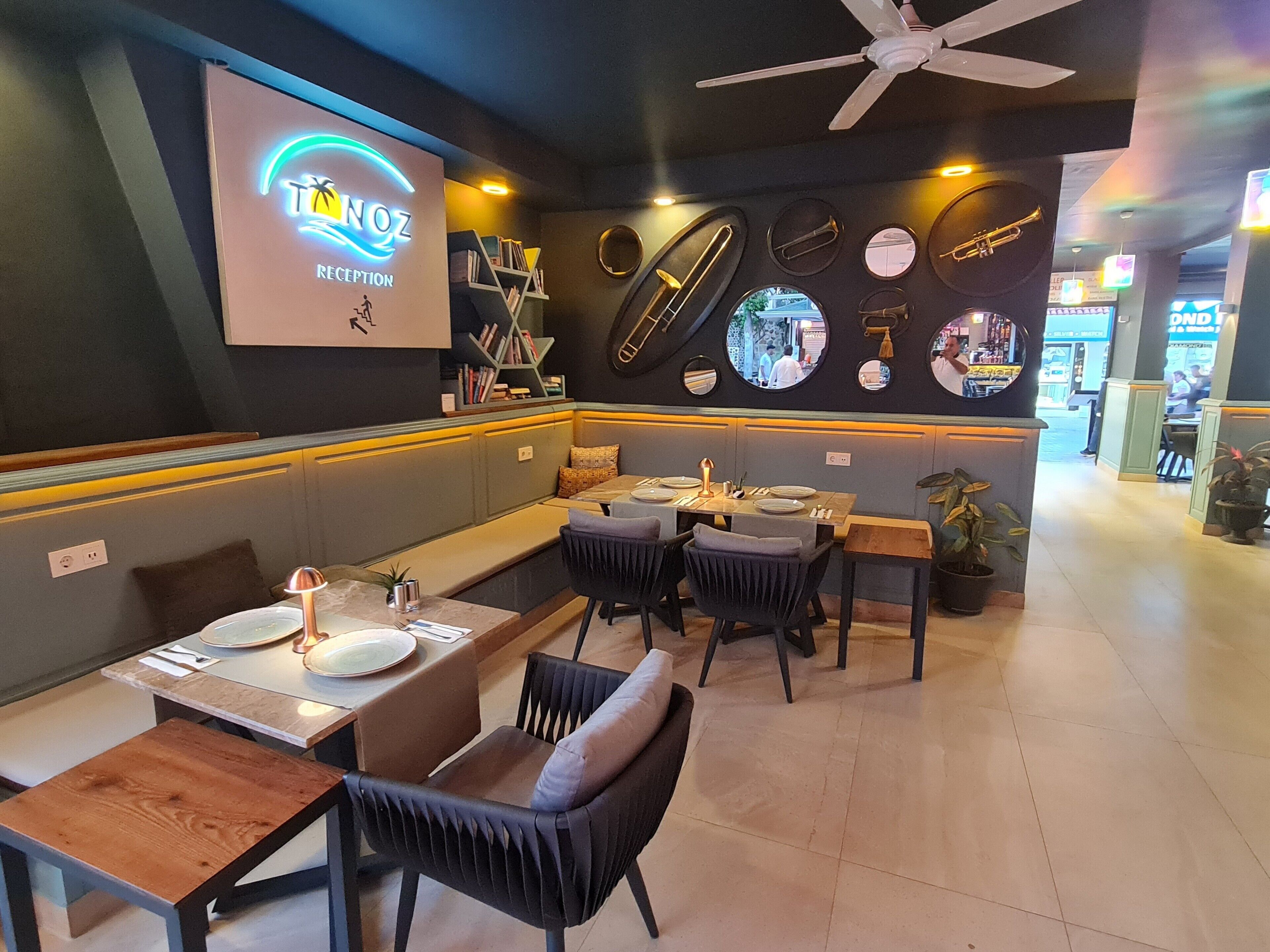 A restaurant interior with a reception area, seating arrangements, and a wall decorated with musical instruments.