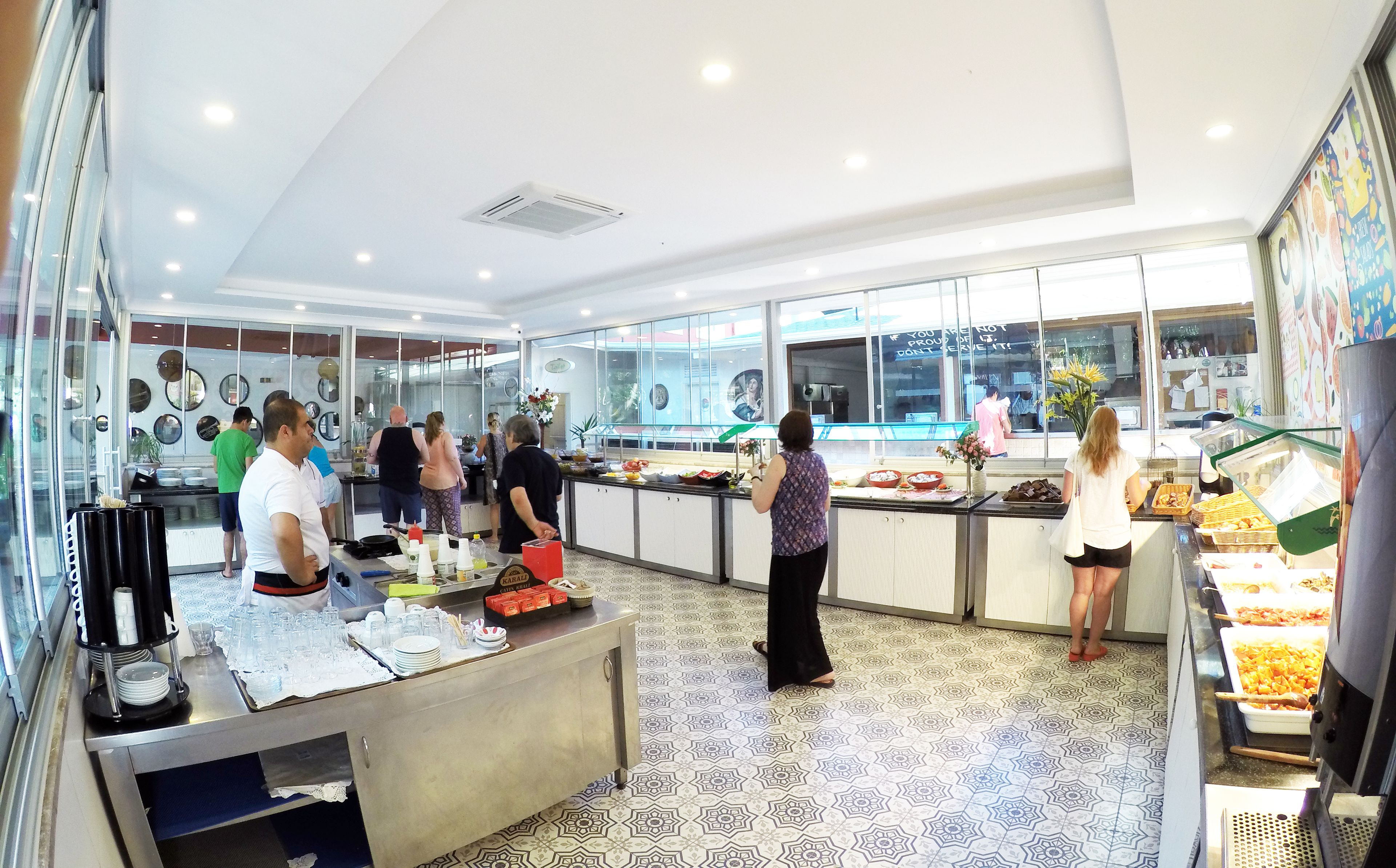 A modern kitchen area with a buffet setup, including a counter with food items and a glass display case.