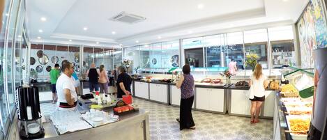 A modern kitchen area with a buffet setup, including a counter with food items and a glass display case.