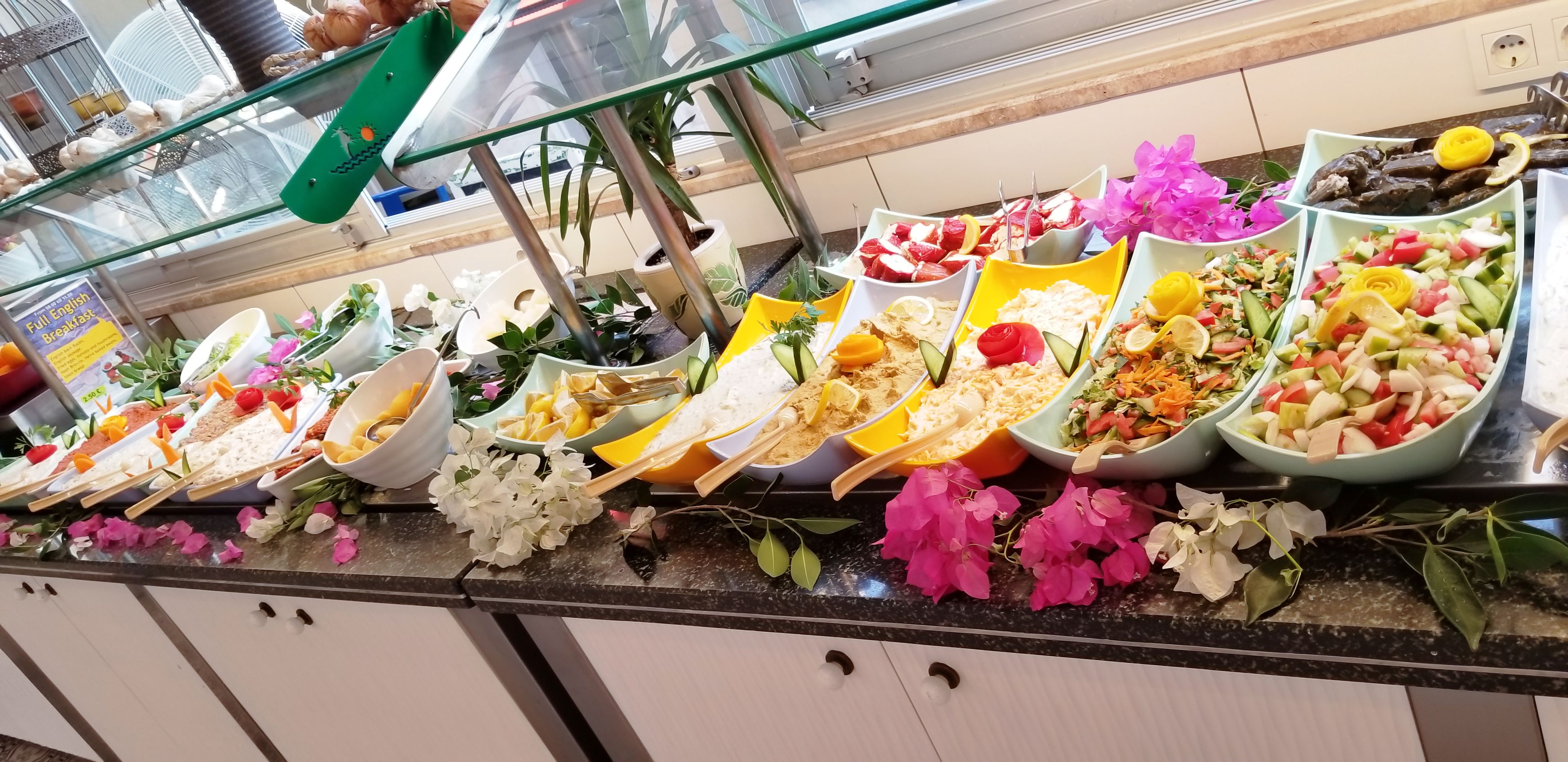 Un buffet proposant une variété de plats et agrémenté de fleurs fraîches.