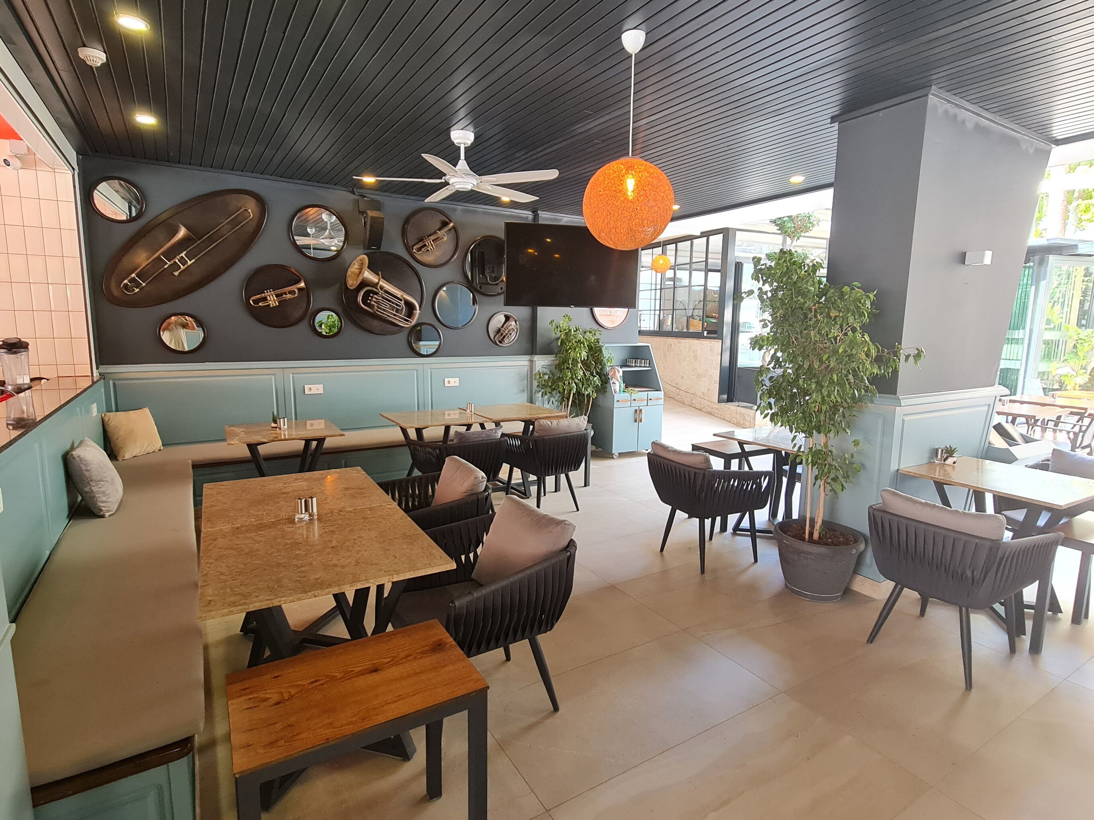 A restaurant interior with a long counter, booths, and tables.