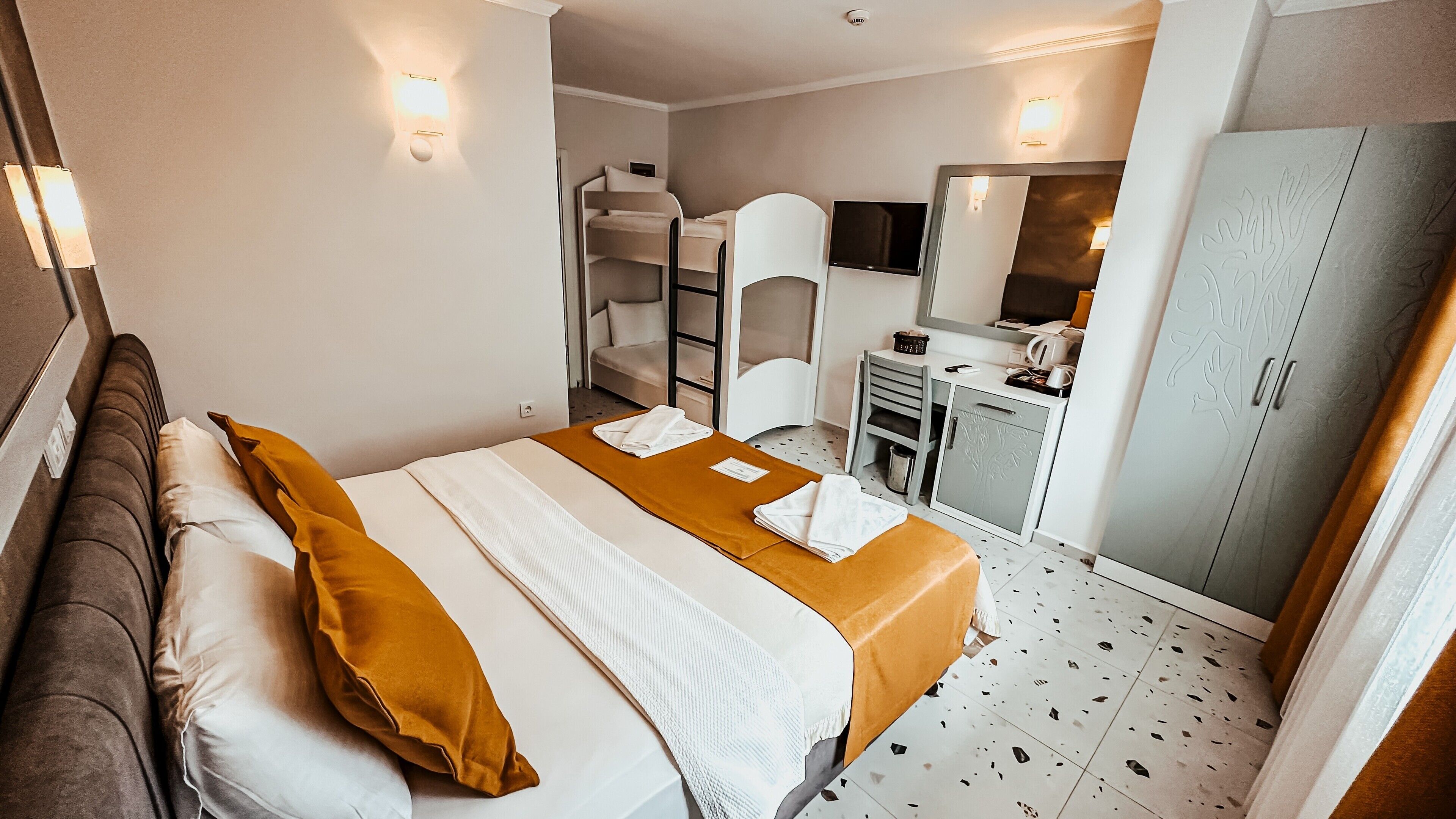 Une chambre d’hôtel équipée d’un lit, d’un bureau, d’une armoire et d’un téléviseur.