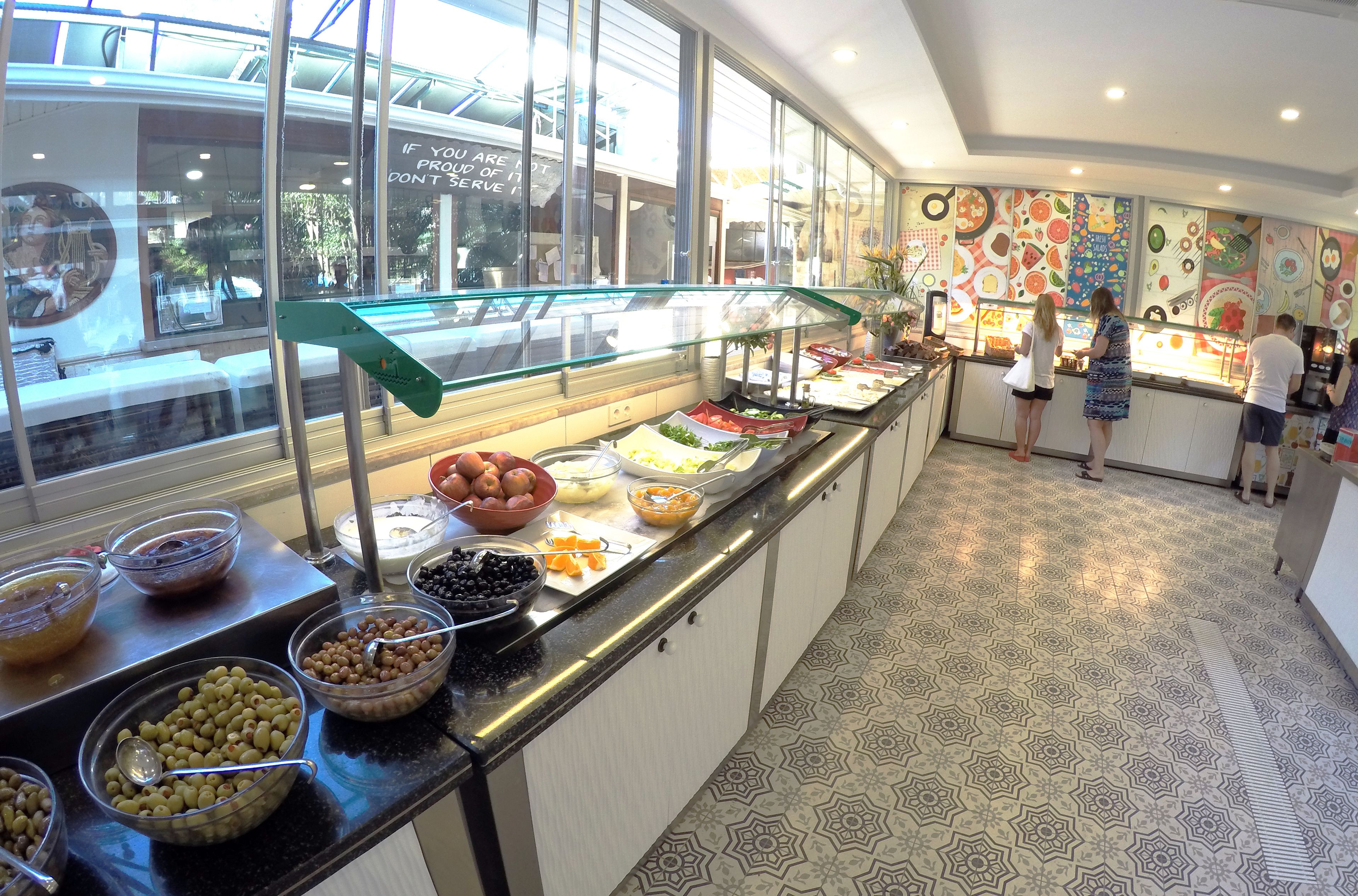 Un espace buffet proposant une variété de plats et offrant une vue sur l’extérieur grâce à de grandes fenêtres.