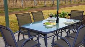 A table set for two with a view of a vineyard in the background. - Talga Estate (Lovedale)