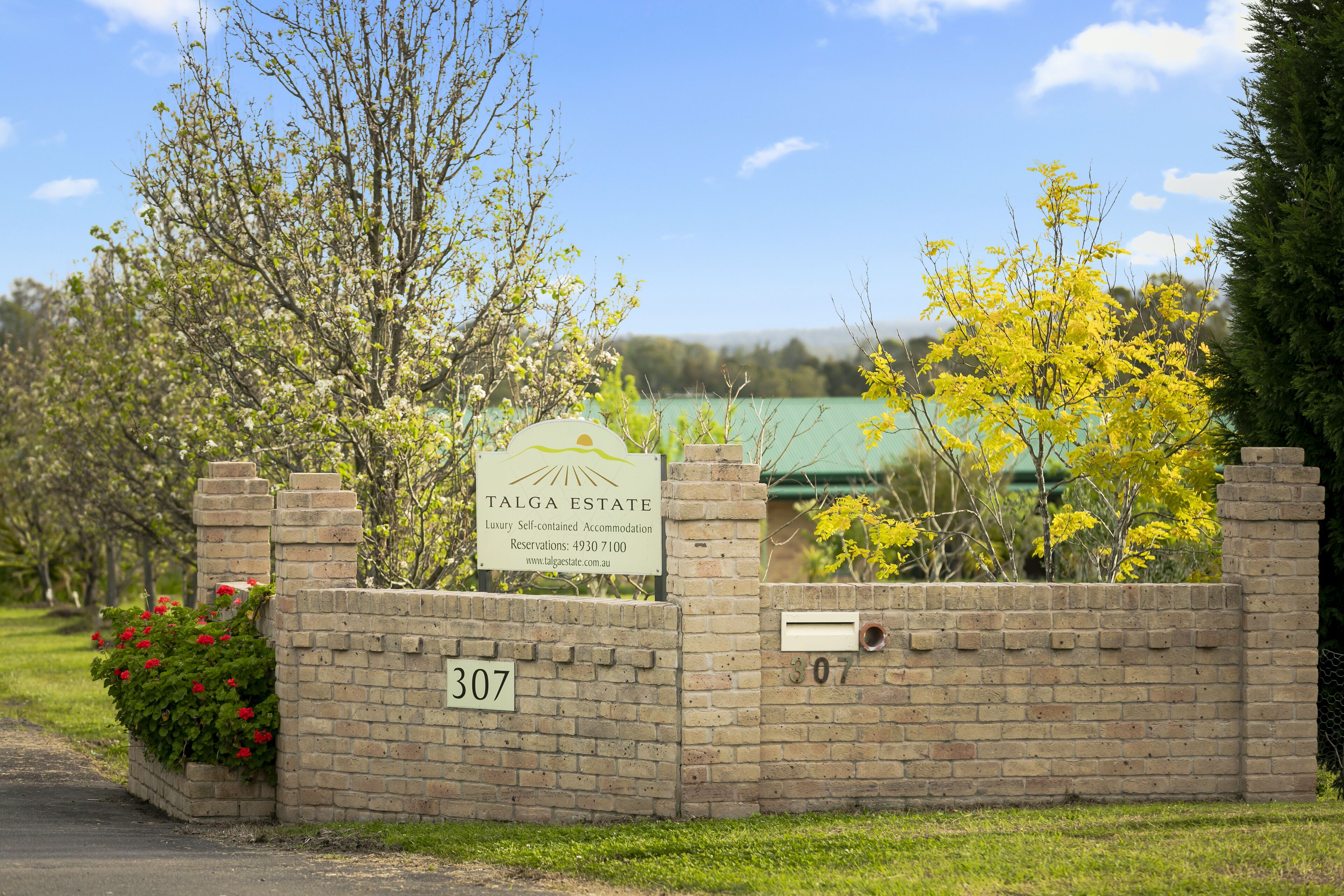 A brick wall with a sign for Talga Estate, a luxury self-contained accommodation with a number 307.