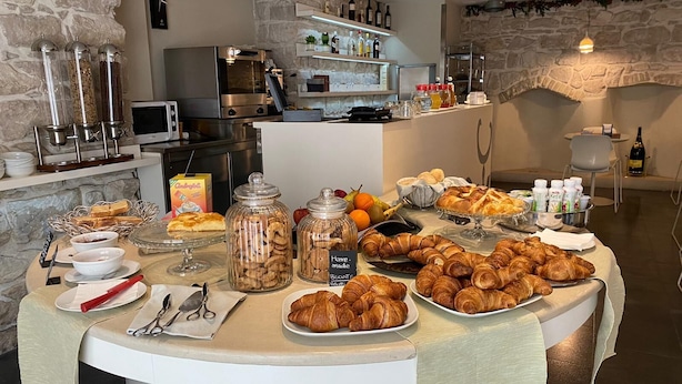 Un bufé de desayuno con pasteles, frutas y bebidas.