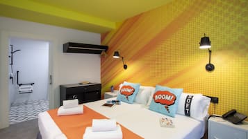 Une chambre d’hôtel avec un lit, des oreillers, une table de chevet, un téléphone et un mur orné d’un motif géométrique.
