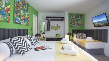 Habitación de hotel moderna con una cama grande, un sofá y un escritorio. Paredes verdes y un ventanal con vista a la playa.