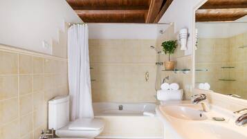 Un baño con inodoro, lavamanos, bañera y ducha.
