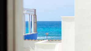 Une vue depuis une fenêtre donnant sur une mer bleue et limpide.