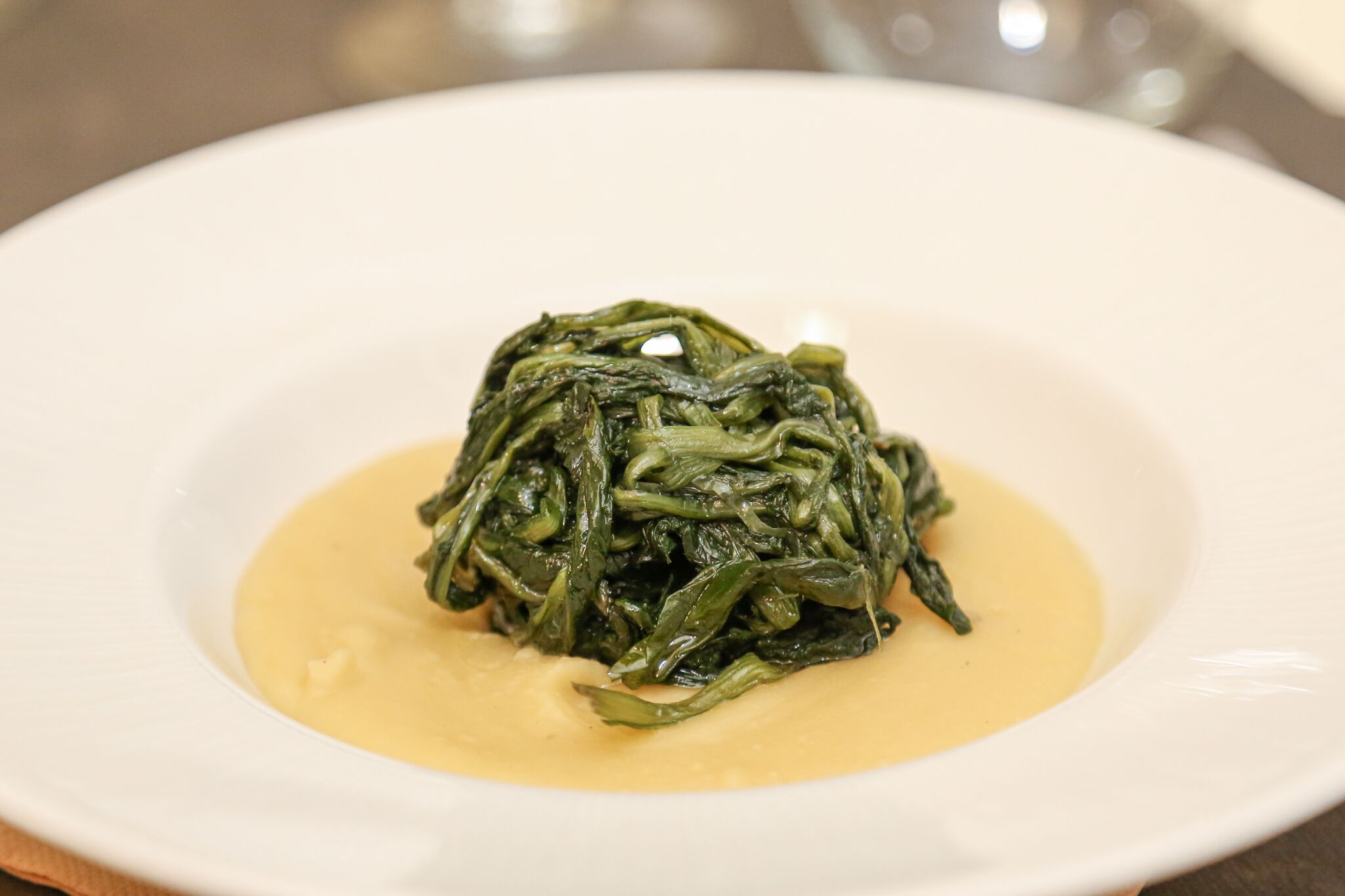 Un piatto di verdure cotte con salsa cremosa.