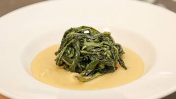 Un piatto di verdure cotte con salsa cremosa.