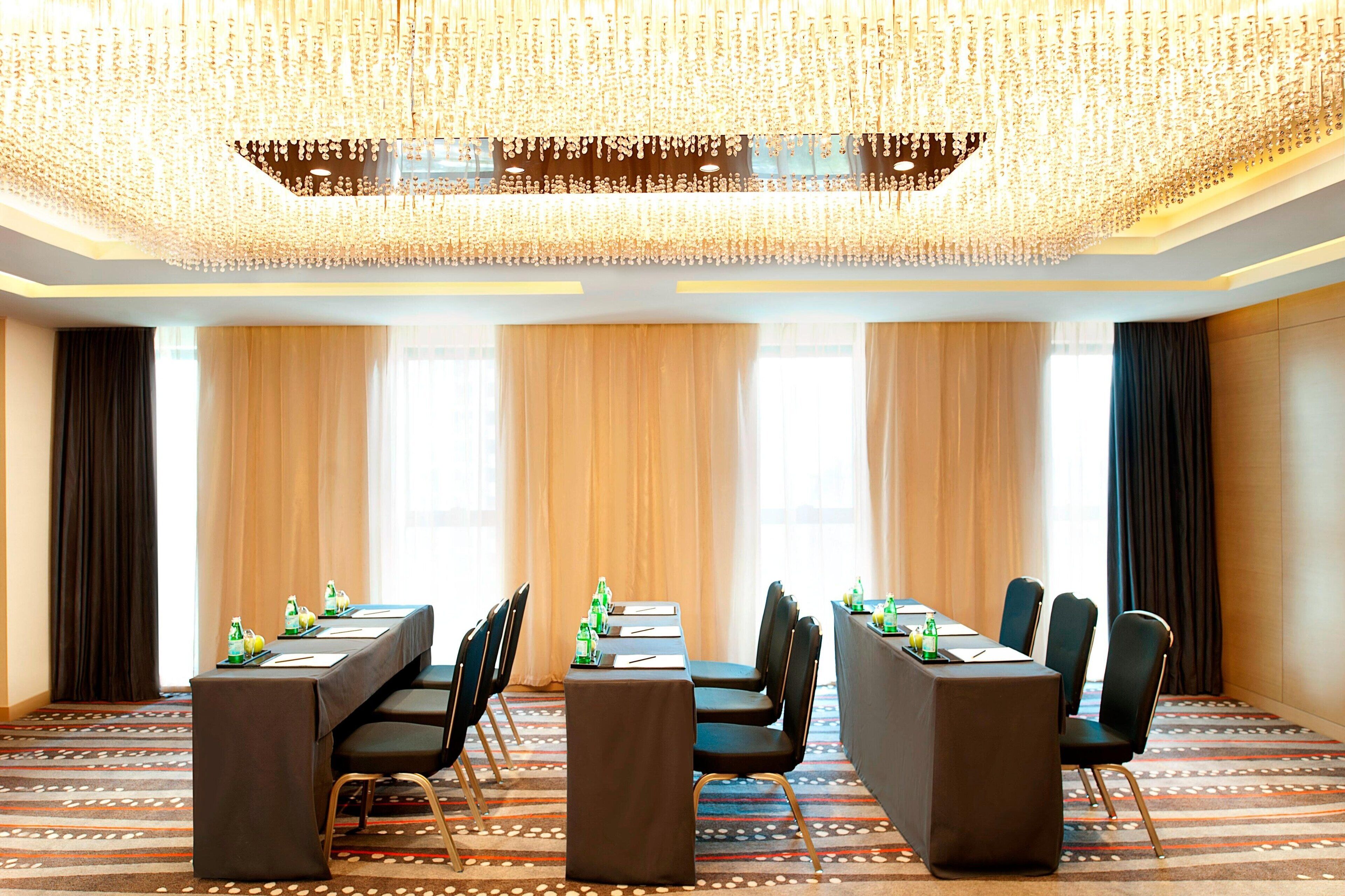 A conference room with a long table, chairs, and a chandelier.
