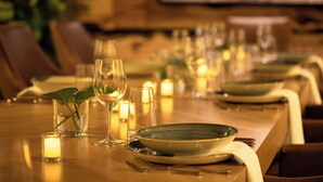 A dining table set with candles, glasses, and a plate. - The Oxford Hotel Bend (Bend)