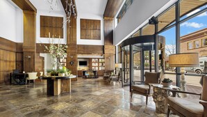 A spacious lobby with a stone floor, wooden accents, and a large window offering a view of the street. - The Oxford Hotel Bend (Bend)