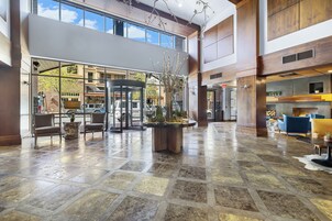 Um hall amplo com porta giratória, área de estar e uma grande janela com vista para o exterior.