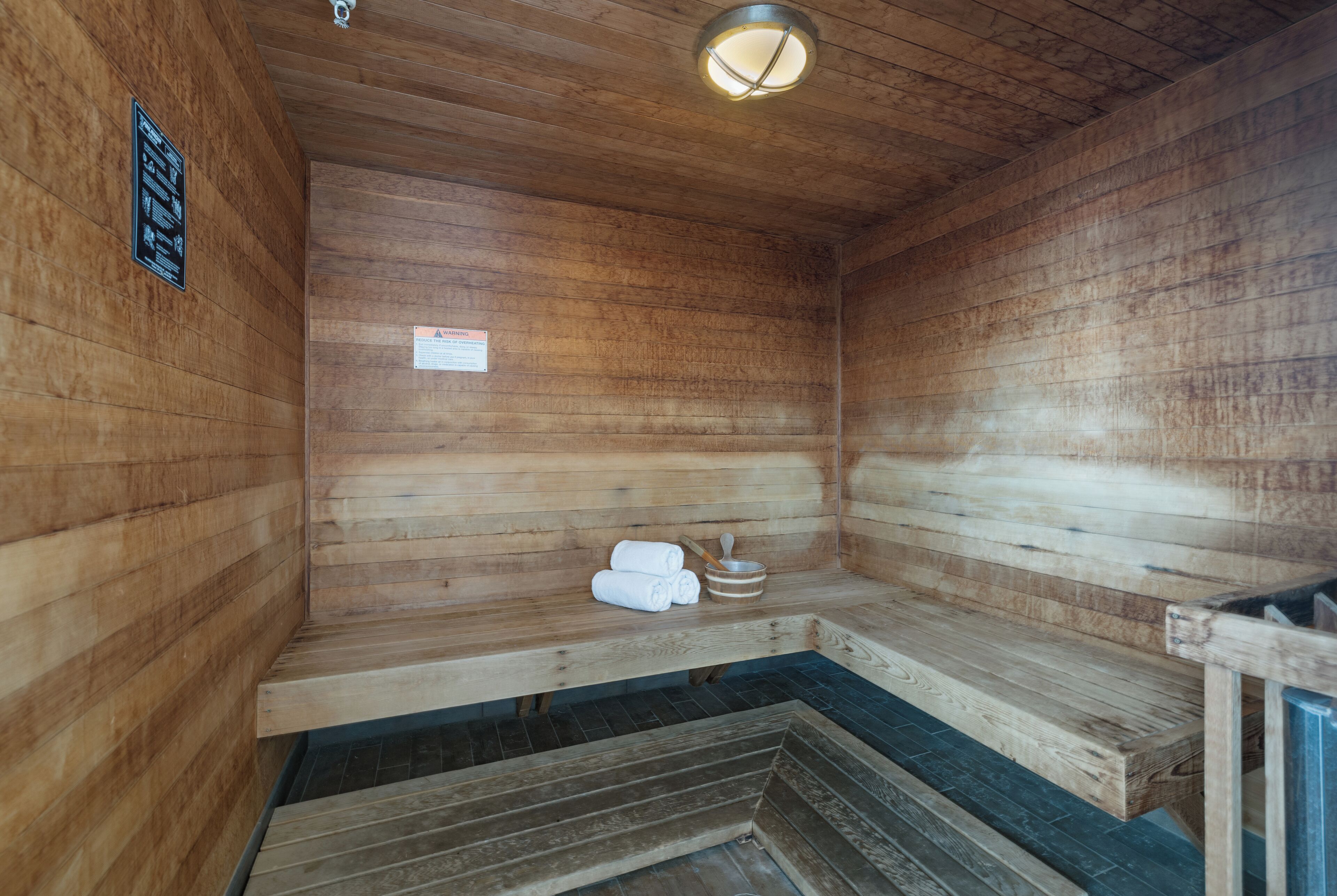 Eine Sauna mit Holzwänden und -bänken, inklusive Handtuchhalter und Heizung.