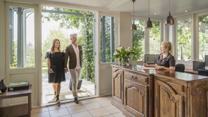 A spacious kitchen with a large island, wooden cabinets, and pendant lighting.