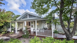 A house with a covered porch, a dining area, and a garden.