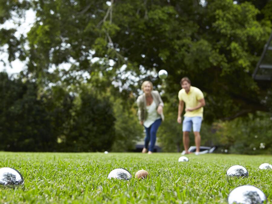A grassy area with golf balls and a person in the background.