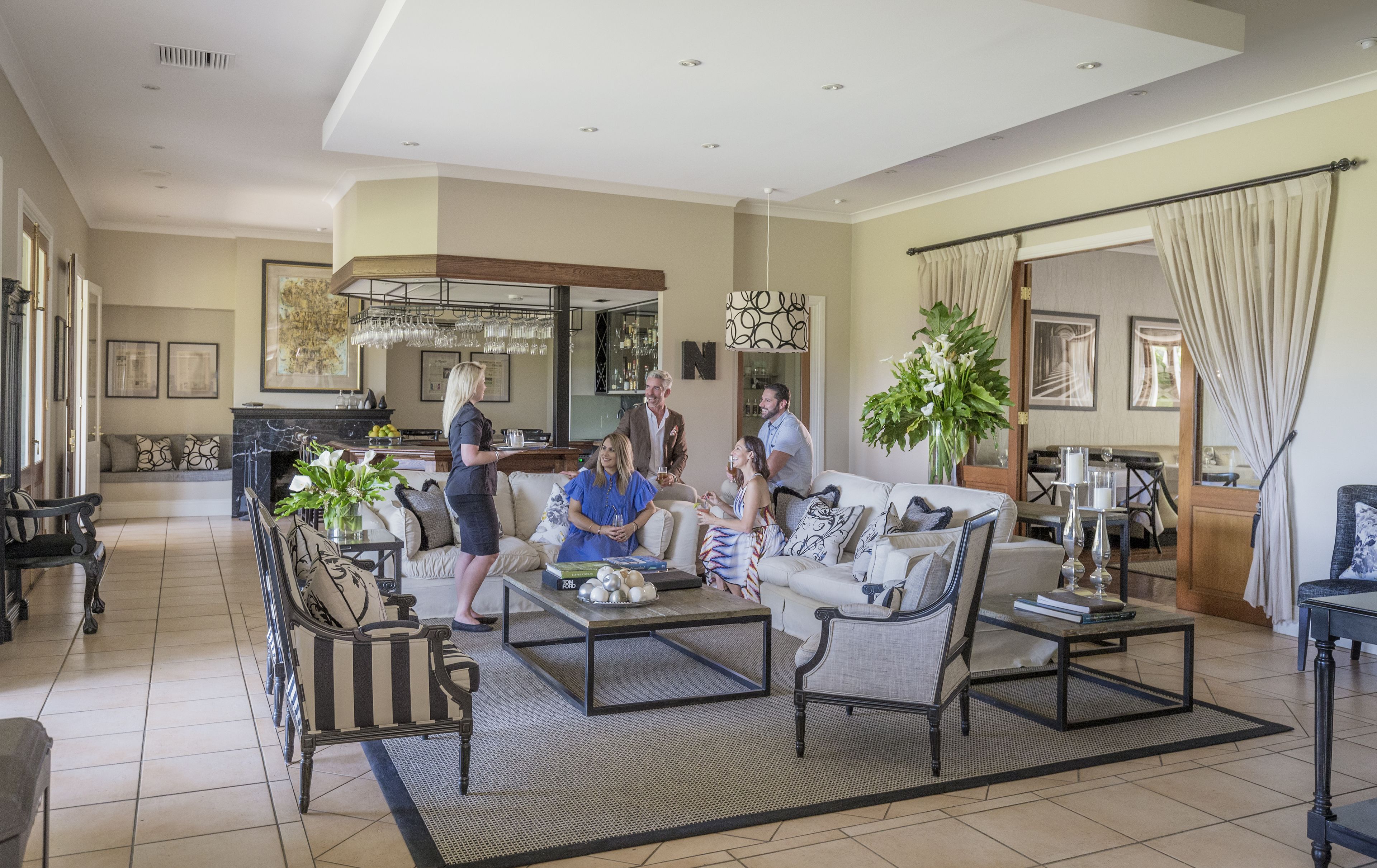 A spacious living room with a large sofa, coffee table, and a dining area with a table and chairs.